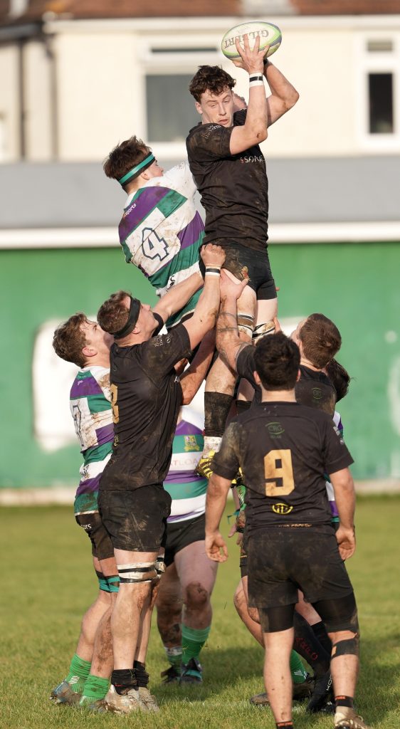 Rugby player jumping in the air to catch ball